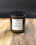 Candle jar with a label on a wooden surface
